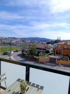 uma varanda com uma mesa e vista para a cidade em Apartamento en Poio-Pontevedra em Poio