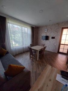 ein Wohnzimmer mit einem Tisch und einem Sofa in der Unterkunft Etci hotel & restaurant in Qəbələ