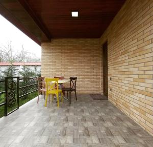 a patio with yellow tables and chairs on a brick wall at Etci hotel & restaurant in Gabala
