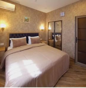 ein Schlafzimmer mit einem großen weißen Bett in einem Zimmer in der Unterkunft Etci hotel & restaurant in Qəbələ