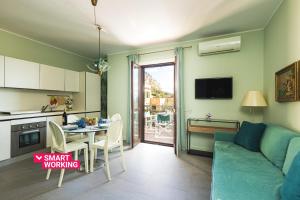 a kitchen and a living room with a couch and a table at Olga's Apartment a Mondello by Wonderful Italy in Mondello +4 photos