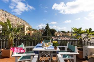 a patio with a table and chairs on a balcony at Olga's Apartment a Mondello by Wonderful Italy in Mondello