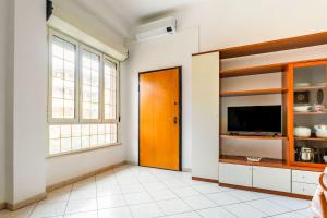 ein Wohnzimmer mit einem TV und einer Tür in der Unterkunft Casa Rosa in Sestu