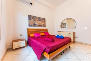 ein Schlafzimmer mit einem großen Bett mit rosa Bettwäsche in der Unterkunft Casa Rosa in Sestu
