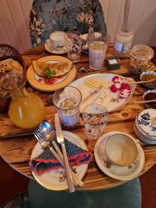 a wooden table with plates and utensils on it at Naturlig Viis in Øster Ulslev