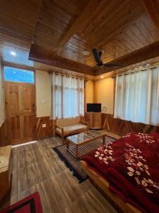 um quarto grande com uma cama e uma mesa em The Lalits Kitchen em Kasol