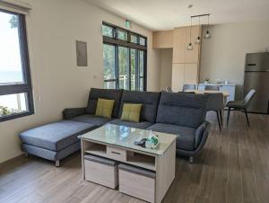 uma sala de estar com um sofá e uma mesa em Ran Ran 29 Guest House em Beigan