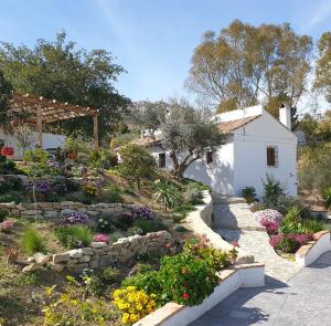 un jardín con un camino de piedra y flores en Finca Altozano - Private pool - Unique client en Valle de Abdalagís