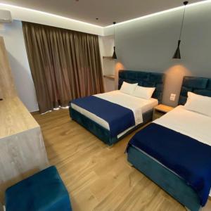 a hotel room with two beds and two chairs at Resol Hotel in Ksamil +8 photos
