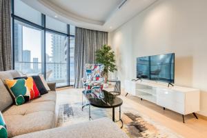 sala de estar con sofá y TV en RH- Downtown Delight, spacious 01BR near Dubai Mall & Burj Khalifa, RP Heights en Dubái