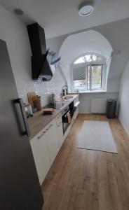 eine Küche mit einem Bogenfenster, weißen Schränken und einem Waschbecken in der Unterkunft Ferienwohnung Lieserpfad in Wittlich
