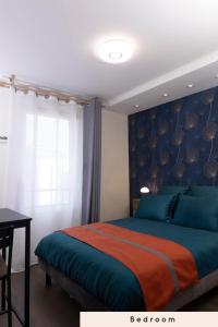 una camera con un letto con una coperta blu e arancione di Chambres cosy près de Paris ad Asnières