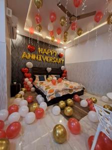 - une chambre avec des ballons et un lit avec un signe d'anniversaire dans l'établissement Aagman Stays By Kasa Lusso, à Faridabad