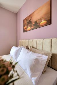 een slaapkamer met een bank en een schilderij aan de muur bij Elsa Apartment in Sarandë