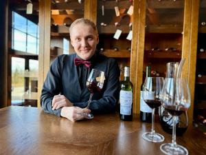 mężczyzna siedzący przy stole z kieliszkiem wina w obiekcie Hotel Seidorf w Sosnówce koło Karpacza w mieście Sosnówka