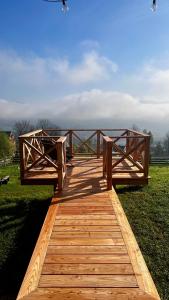 a wooden bridge with two benches on top of a field at Somnium Pieniny in Tylka
