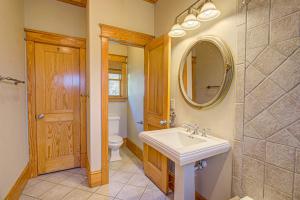 a bathroom with a sink and a toilet and a mirror at IC3 The Wright Getaway Dog Friendly in Manteo