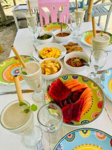 Una mesa con platos de comida y bebidas sobre ella. en Dream Makers Beach House, en Gili Air