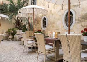 ヴェネツィアにあるPalazzo Paruta & Wellness Suitesのテーブルと椅子、パラソル付