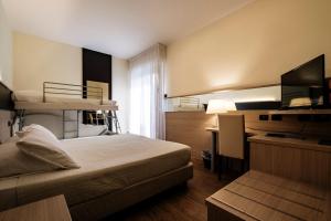里乔内Augustus Hotel Riccione的配有双层床和书桌的酒店客房