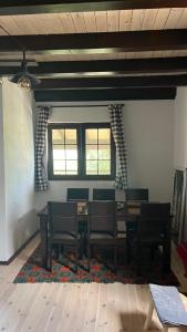 uma sala de jantar com uma mesa e cadeiras e duas janelas em Lazarus house em Berane