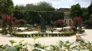 park z kwiatami i posągiem w środku w obiekcie Hôtel Henri IV Rive Gauche w Paryżu