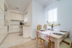 a kitchen and dining room with a table and chairs at Beautiful Apartment with a Spacious Balcony in Wrocław by Renters in Wrocław