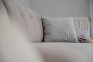a white bed with a pillow on top of it at Beautiful Apartment with a Spacious Balcony in Wrocław by Renters in Wrocław