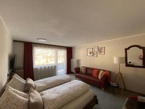 Alpinum Hostel في ببيرفيير: غرفة معيشة مع أريكة وكرسي احمر