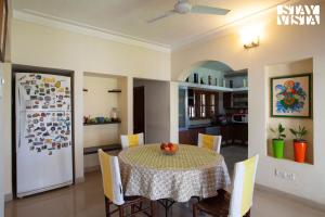 a kitchen and dining room with a table and chairs at StayVista at Mikkie House 3BHK Villa Combination of Bricks & Stone - Breakfast Included in Aivarkhandpur