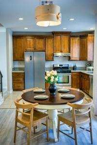 a kitchen with a table with chairs and a refrigerator at Modern Refreshing Home near disneyland@ in Fullerton