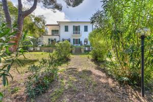 a white house in the middle of a garden at Cesarina Bilo in Procchio