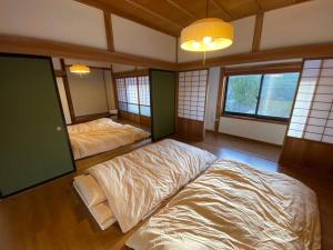 2 Betten in einem Zimmer mit Fenstern in der Unterkunft ゲスト専用プライベートサウナ付き一棟貸し宿 In Utero in Kashiwazaki