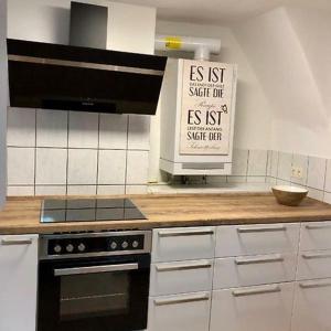 una cocina con fogones y un cartel en la pared en Zimmer in Kyritz, en Kyritz