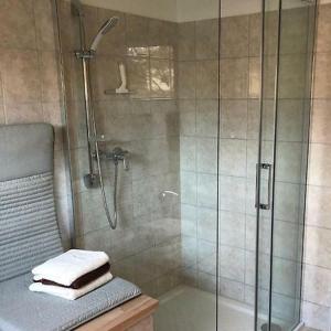 baño con ducha y toallas en un banco en Zimmer in Kyritz, en Kyritz