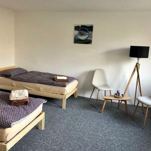 1 dormitorio con 2 camas, lámpara y silla en Zimmer in Kyritz, en Kyritz