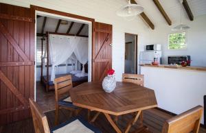 a kitchen and dining room with a wooden table and chairs at Gîte Pointe des Châteaux in Saint-François