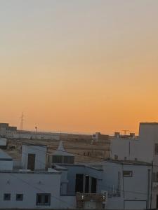 a group of buildings with the sunset in the background at Appartement Nouakchott in Nouakchott