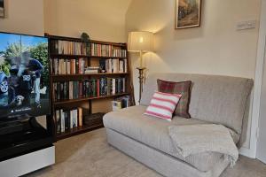 sala de estar con sofá y TV de pantalla plana en Entire Cottage in Burford Centre, Cotswolds, en Burford