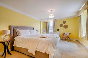 1 dormitorio con 1 cama grande y paredes amarillas en Entire Cottage in Burford Centre, Cotswolds, en Burford