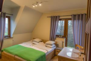 Schlafzimmer mit einem Bett, einem Tisch und Fenstern in der Unterkunft U Suchowiana in Zakopane