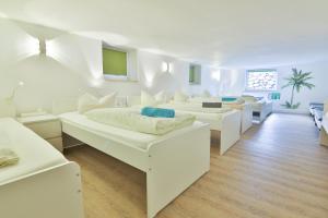 a white room with two beds and a couch at Moderne helle Ferienwohnung Allgäu am See Munich Castle in Lechbruck