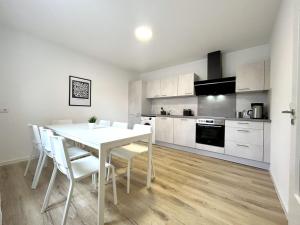 een keuken en eetkamer met een witte tafel en stoelen bij Nice Apartment in Büchenberg in Eichenzell