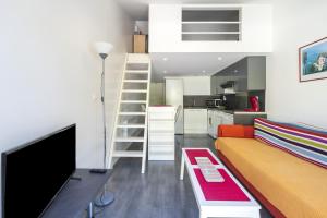 Il comprend un salon avec un canapé et une cuisine. dans l'établissement Appartement de charme - spa privé, à Biarritz