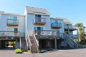 a large apartment building with stairs in front of it at GTS27 Seaside Retreat 7 Min Walk to Beach in Duck