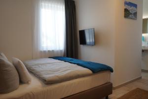 una camera da letto con un letto e una TV a parete di Eco Motel a Wallersdorf