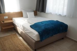 Un dormitorio con una cama con una manta azul. en Eco Motel, en Wallersdorf