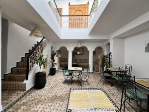 a room with a staircase and a table and chairs at Riad Sarah Sabrina in Marrakesh