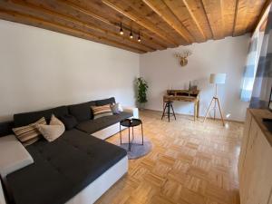 a living room with a couch and a piano at Almufer-Appartements in Grünau im Almtal