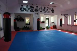 a gym with two boxing bags on a blue floor at Geovita Lądek Zdrój in Lądek-Zdrój